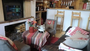 A cozy living room with a fireplace, a striped table, and a leather sofa. - Auberge Du Pont De L'Alp (Monetier-les-Bains)