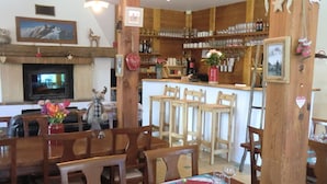 A cozy restaurant with wooden furniture, a bar area, and various decorations. - Auberge Du Pont De L'Alp (Monetier-les-Bains)