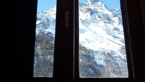 A window with a view of a snow-covered mountain and forest. - Auberge Du Pont De L'Alp (Monetier-les-Bains)