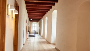 A corridor with wooden beams, white walls, and arched windows. - Danhostel Vitskøl Kloster (Logstor)