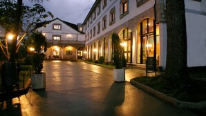A hotel with a courtyard, stone arches, and multiple windows. - Hotel Balneario Baños da Brea (Vila de Cruces)