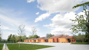 A row of orange-roofed buildings with a paved walkway in front.