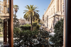 A street view with a palm tree and buildings.