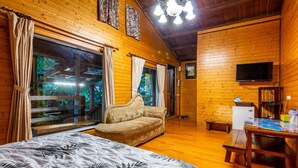 A wooden cabin room with a bed, sofa, and a table. - Water Villa (Wujie)