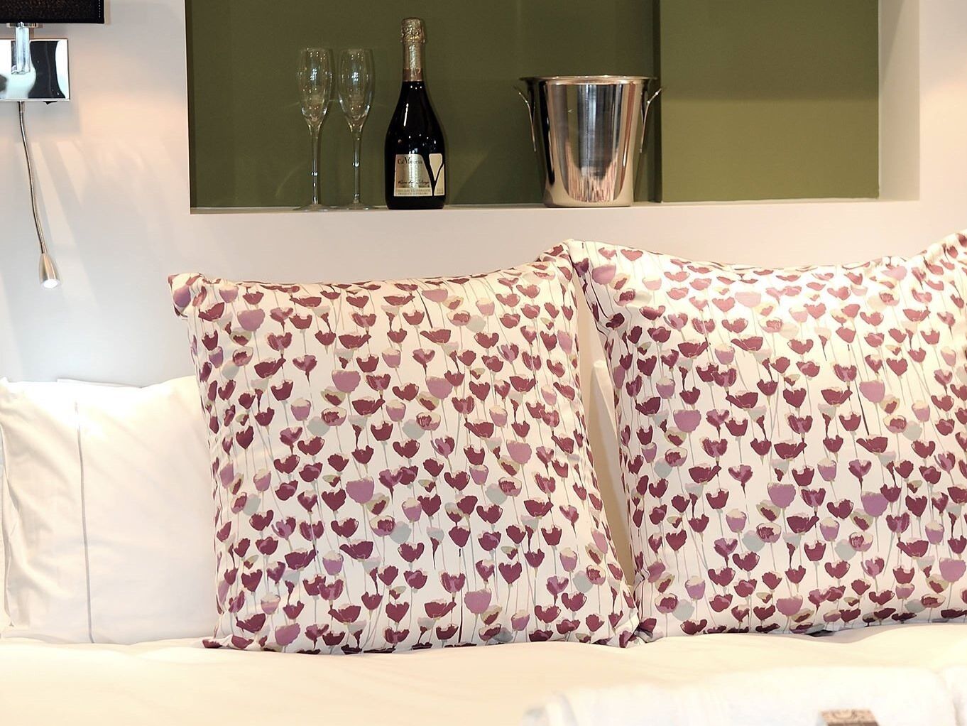 A white sofa with two decorative pillows featuring a heart pattern.