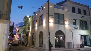 Un edificio con un letrero que dice 'B&B Casa di Emma', que indica una casa de huéspedes. Tiene varios balcones y una entrada visible.