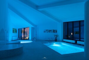 Un baño moderno con una bañera grande, ducha y una pequeña zona de piscina.
