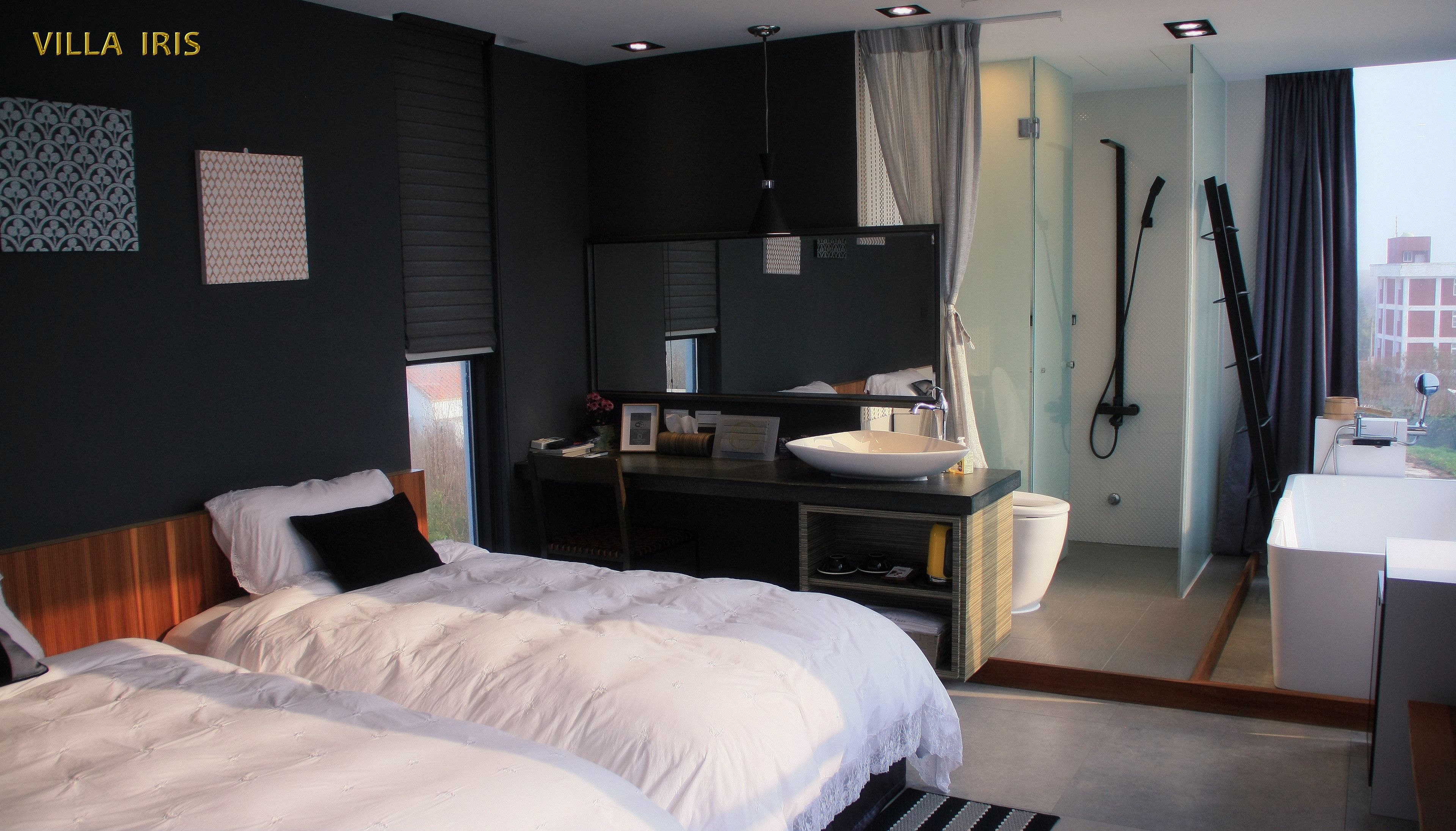 Une chambre d’hôtel avec deux lits, une salle de bain avec douche et vue sur la ville.