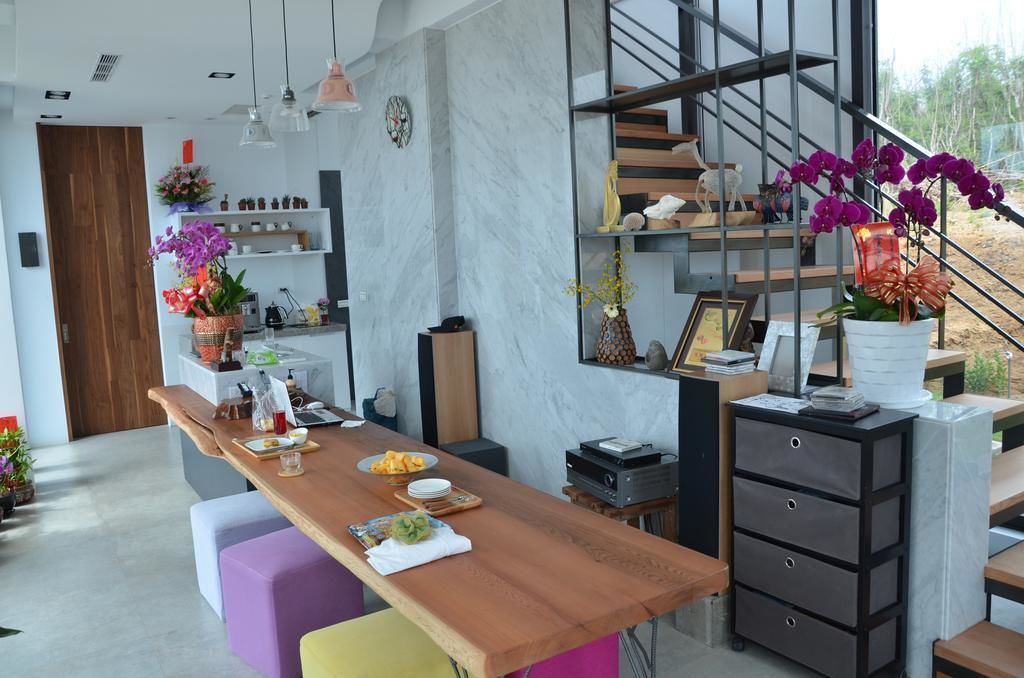 A modern kitchen with a wooden countertop, a built-in stove, and a staircase with a railing.
