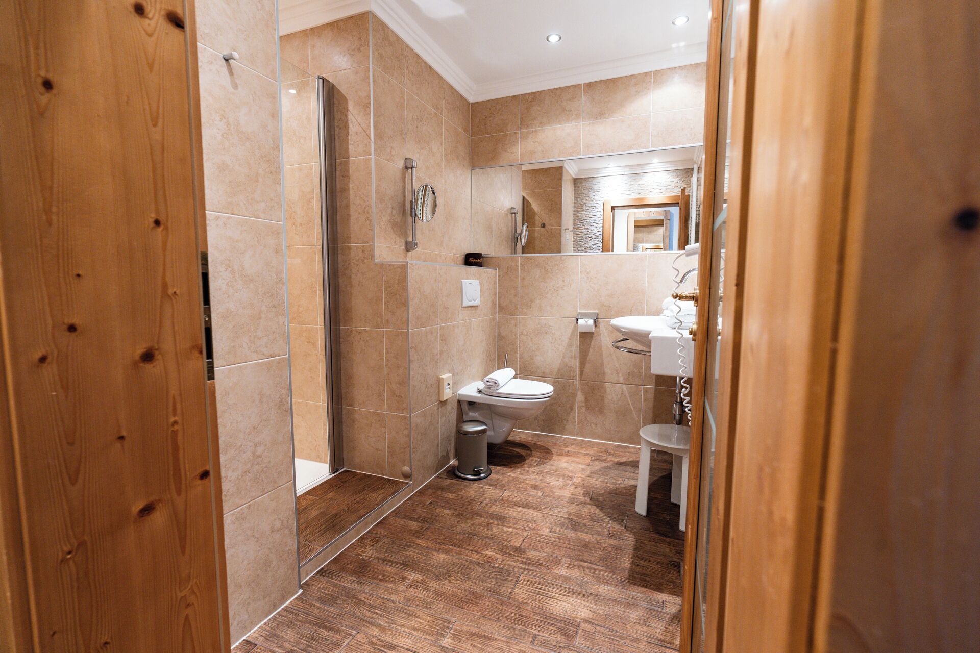 A modern bathroom with a shower, toilet, and sink.