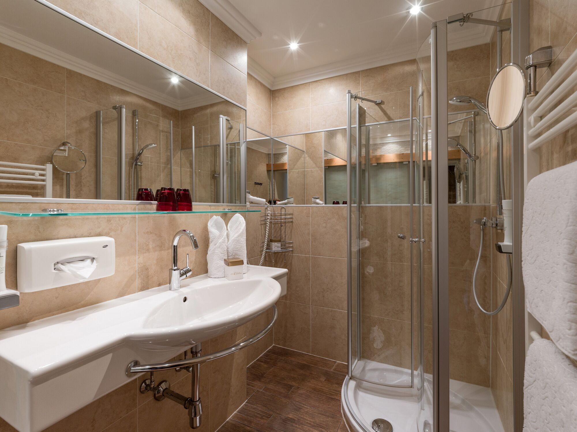 A modern bathroom with a glass-enclosed shower, a large sink, and a mirror above the sink.