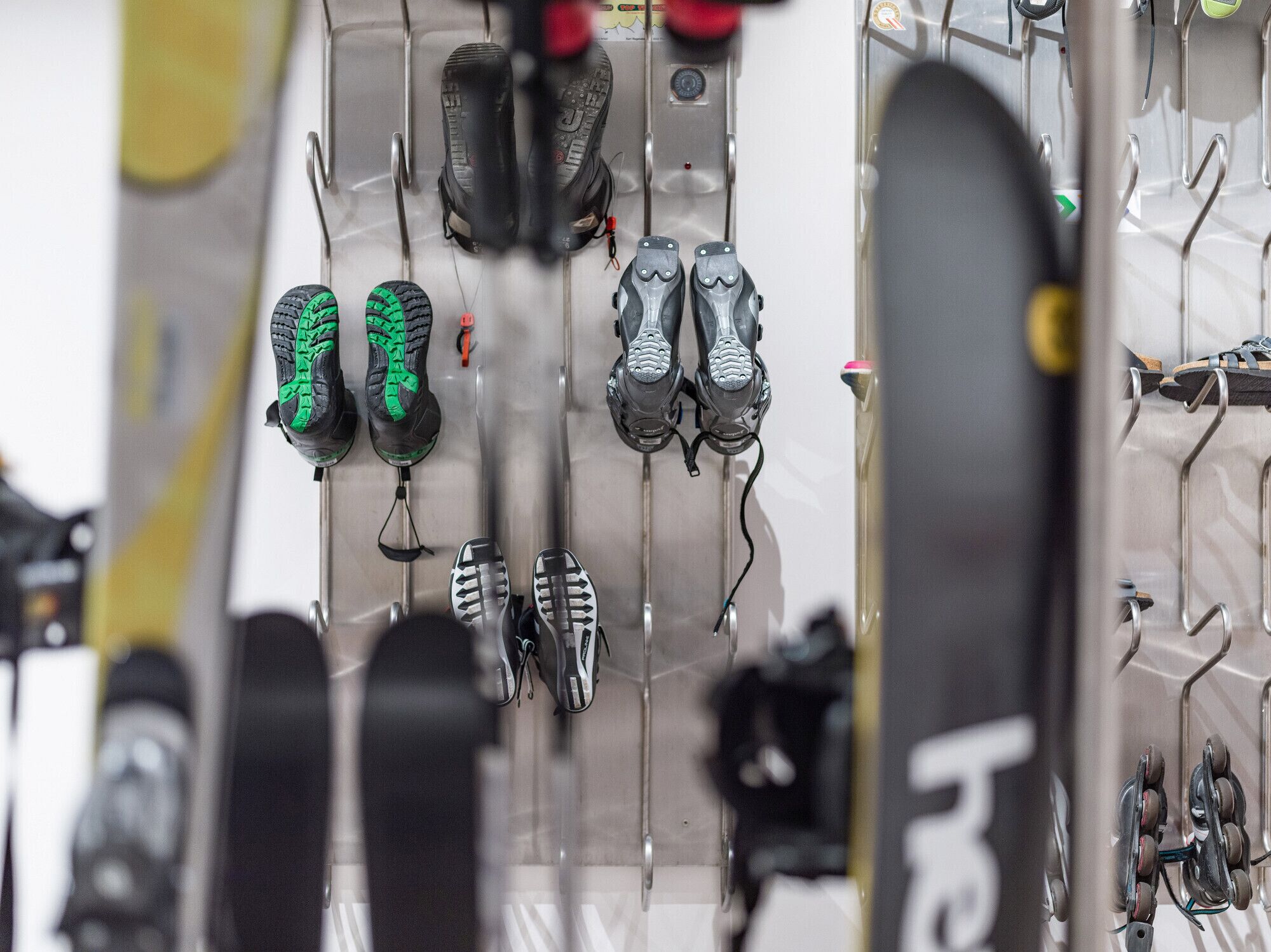 Une rangée de paires de skis suspendues à un porte-skis.