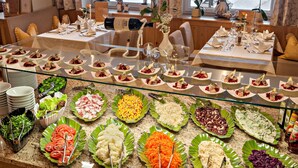 En buffet med forskellige retter og et spiseområde med borde dækket til et måltid.