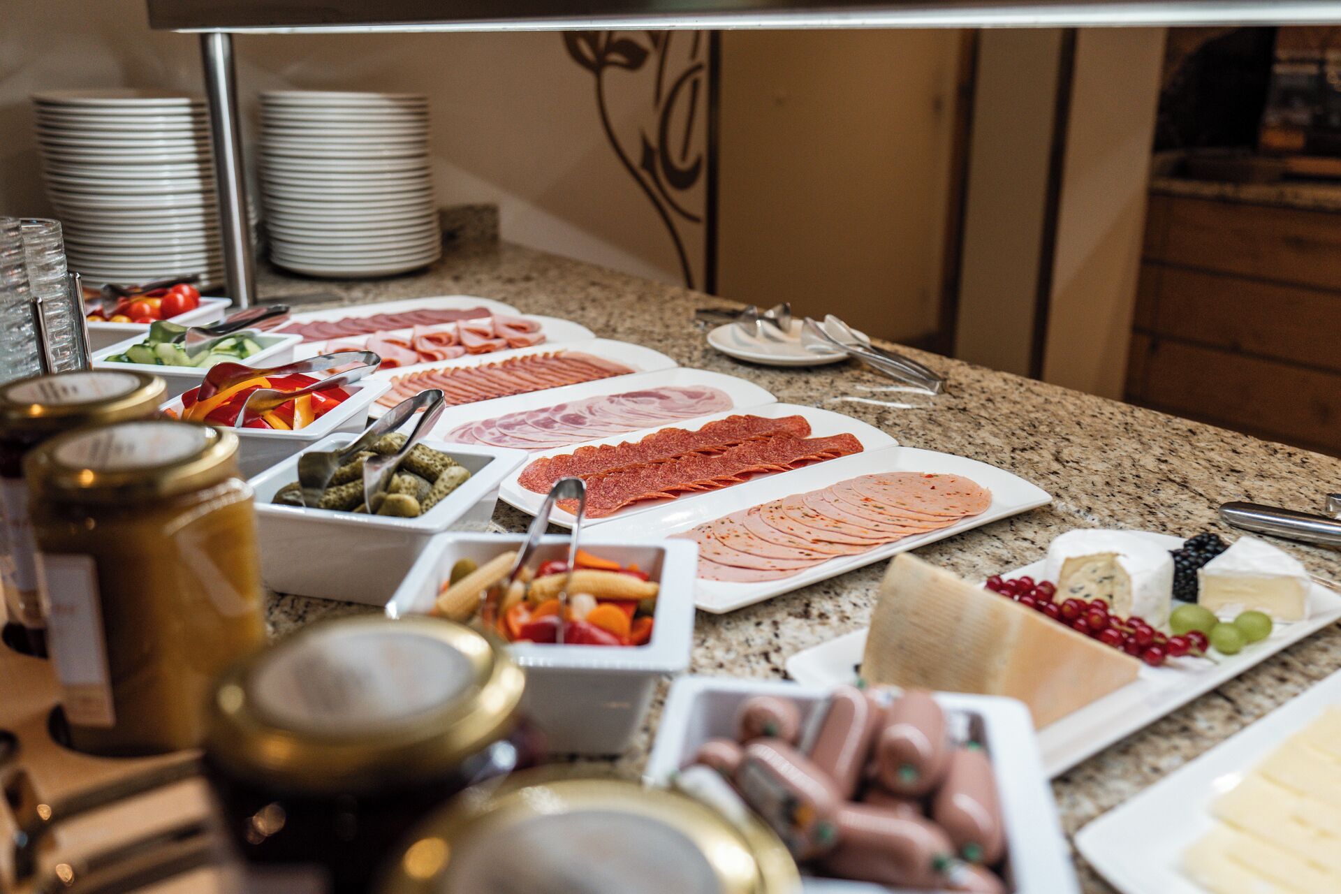A buffet with various meats, cheeses, and fruits.
