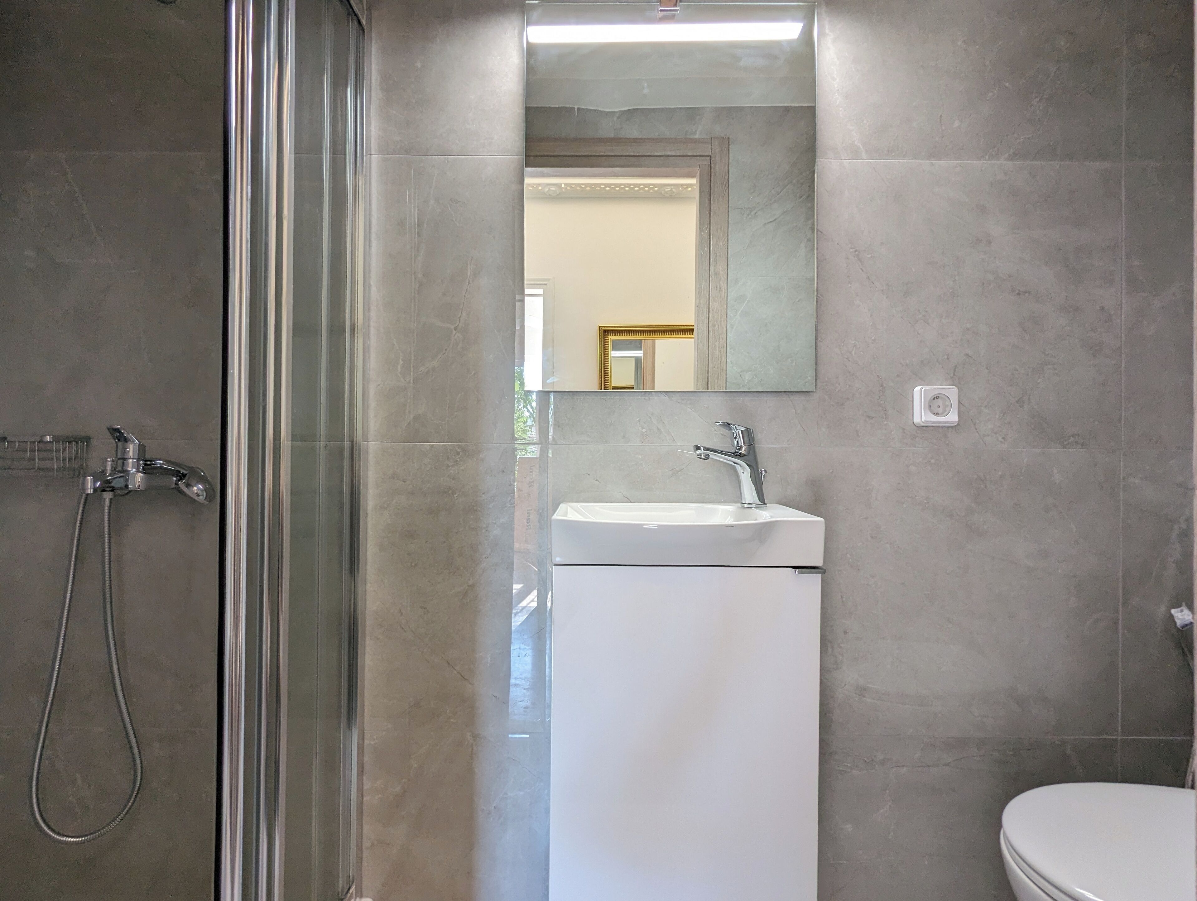 Une salle de bain avec une douche, un lavabo et des toilettes.