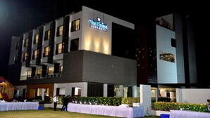 A multi-story hotel with a prominent sign reading "The Divine Resort." - The Divine Resort (Veraval)
