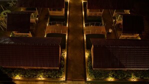 A modern building with multiple units, each featuring a sloped roof and a central courtyard. - The Divine Resort (Veraval)