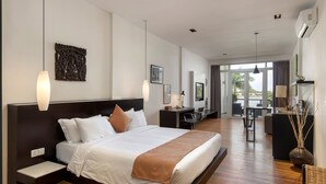 A modern hotel room with a large bed, a desk, and a view of the outdoors. - Tao Riverside Residence (Phnom Penh)