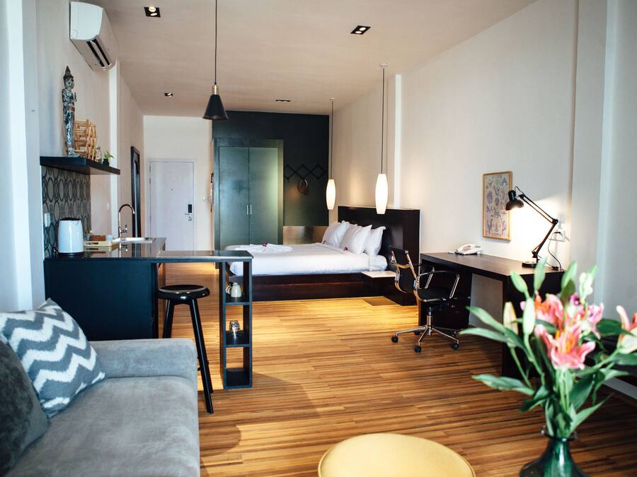 Una habitación de hotel moderna con cama, escritorio y zona de estar.