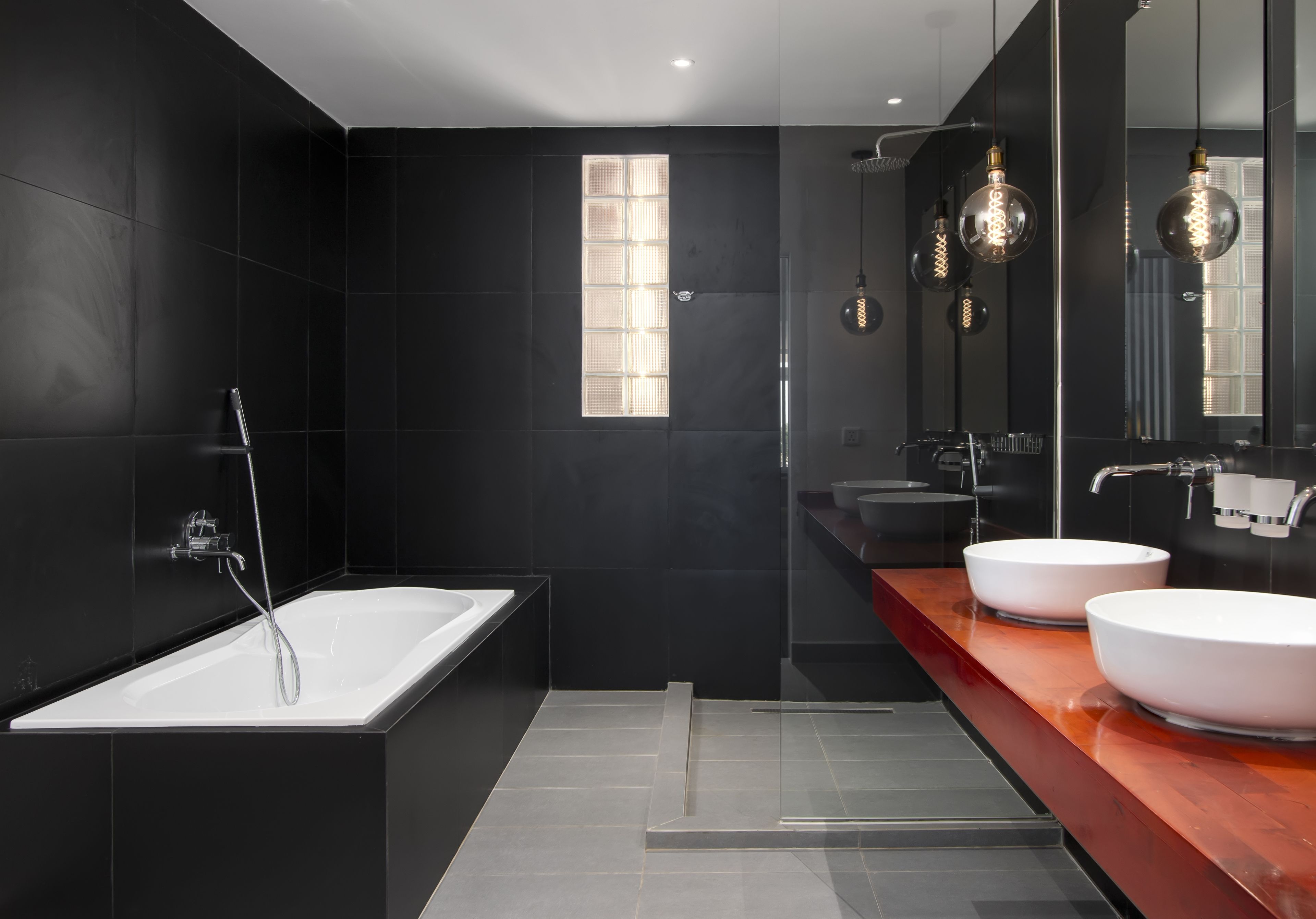 Ein modernes Badezimmer mit Badewanne, zwei Waschbecken und einem großen Spiegel.