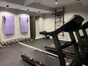 A gym with a treadmill, kettlebells, and a pull-up bar. - Avena Boutique Hotel by Artery Hotels (Kraków)