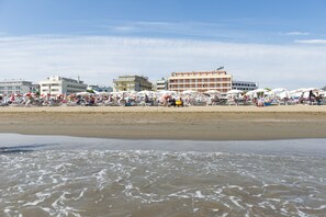 Privat strand, hvit sand, solsenger og parasoller