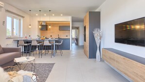 Una sala de estar moderna con un sofá, una mesa de centro y un televisor montado en la pared.
