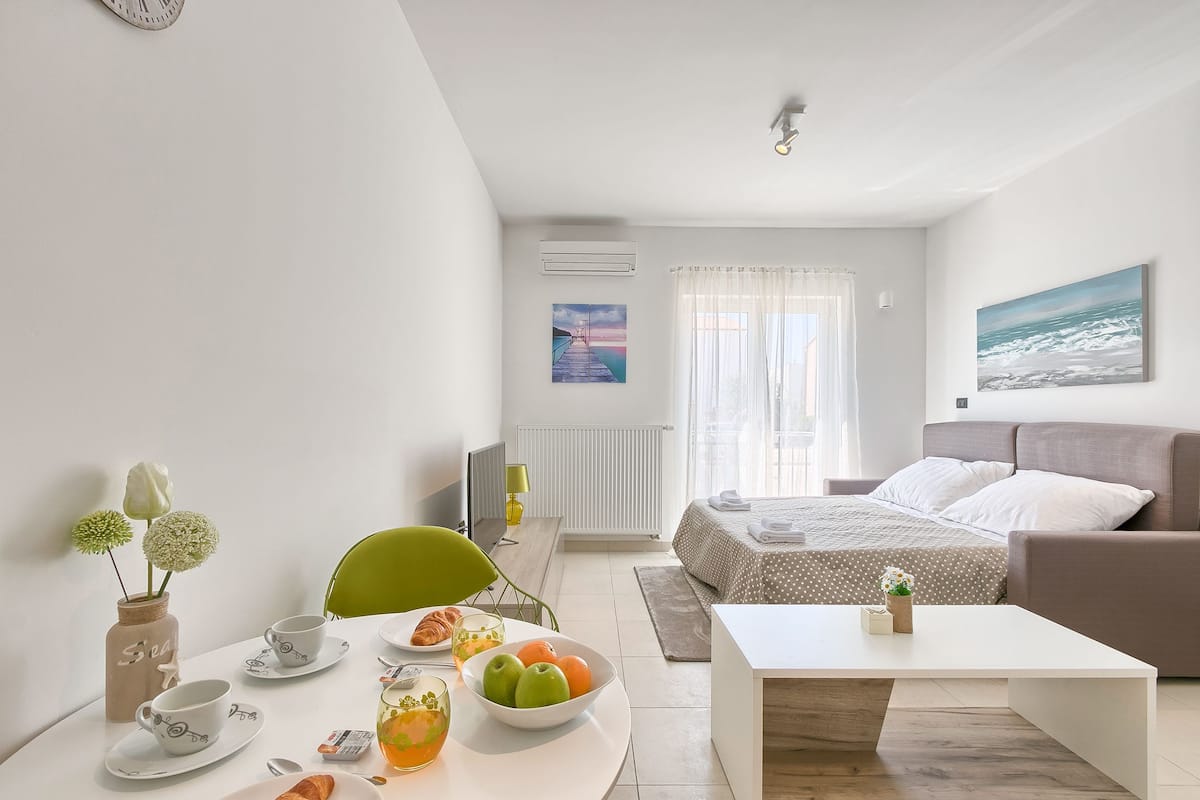 Ein modernes Hotelzimmer mit Essbereich, einem Bett mit Blick und einem Bild an der Wand.