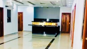 A spacious hotel lobby with a central reception desk, a polished floor, and a modern ceiling design. - Hotel Fenix (Iquitos)