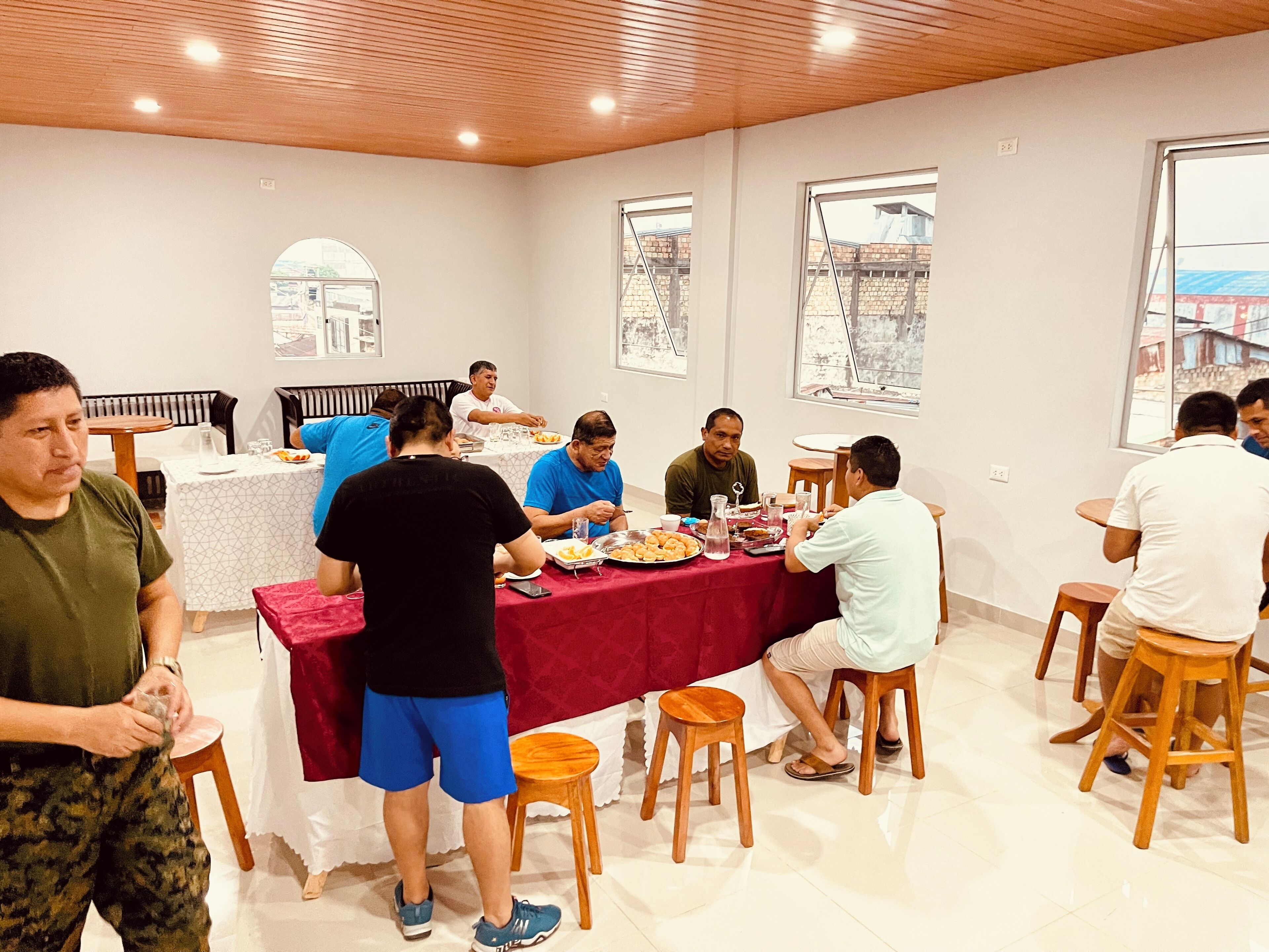 A dining area with a long table set for a meal, surrounded by wooden chairs.