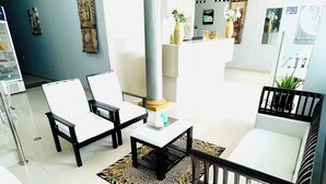 A modern living room with a sofa, chairs, a coffee table, and a patterned rug. - Hotel Fenix (Iquitos)