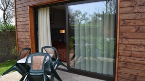 A wooden exterior with a sliding glass door leading to an interior space.