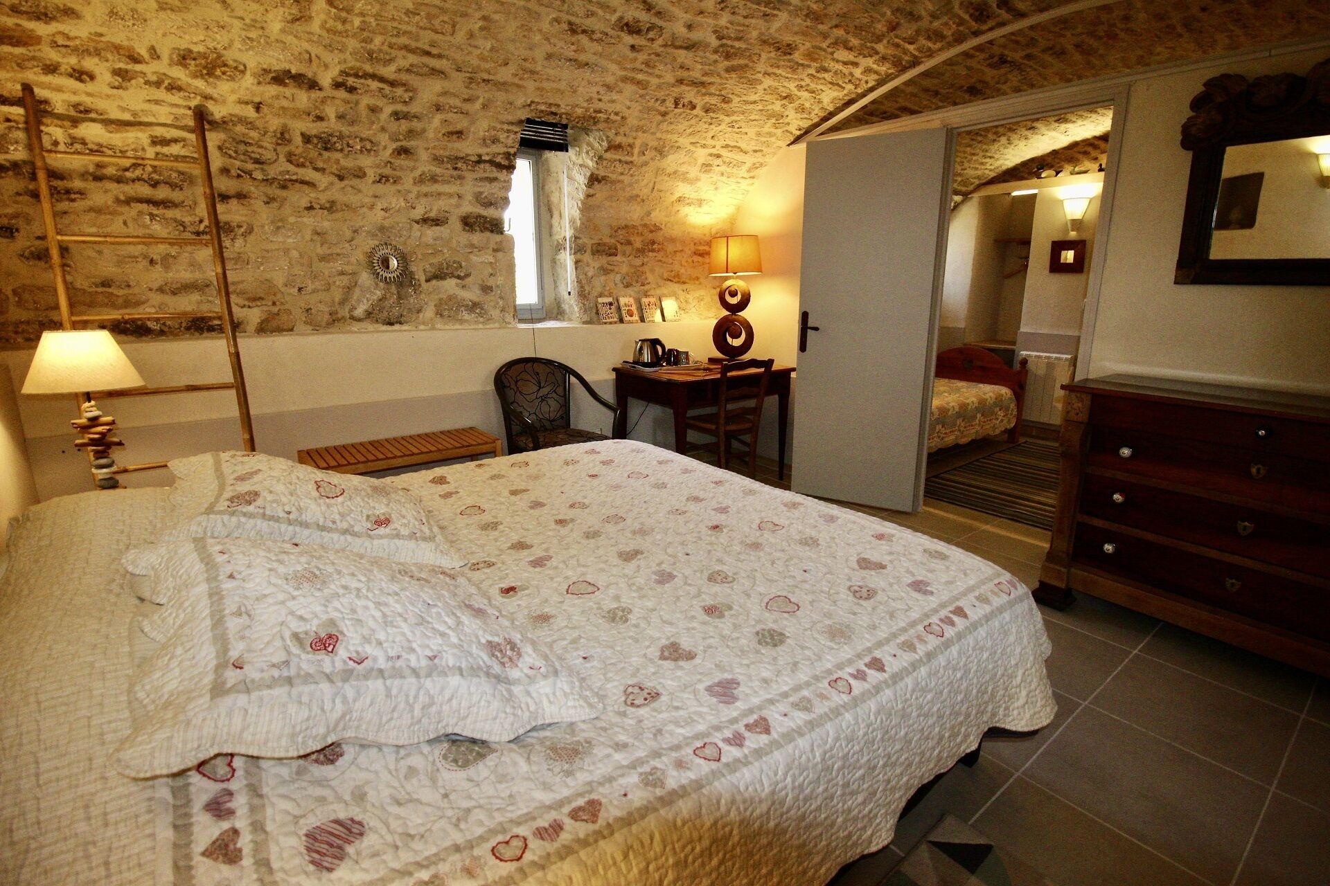 Un dormitorio con una cama grande, un escritorio, una silla y un aparador.