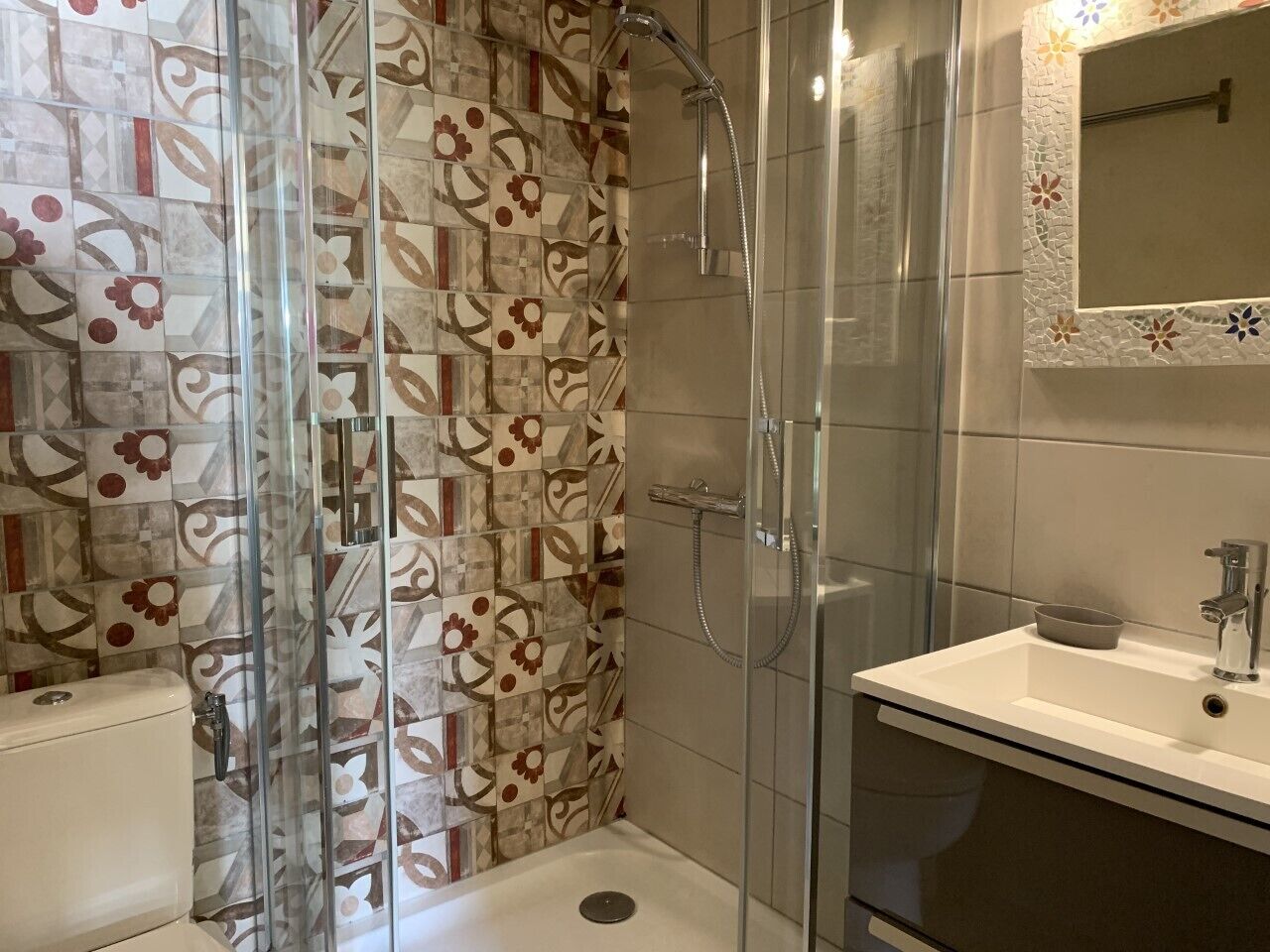 Une salle de bain avec douche, toilettes et lavabo.