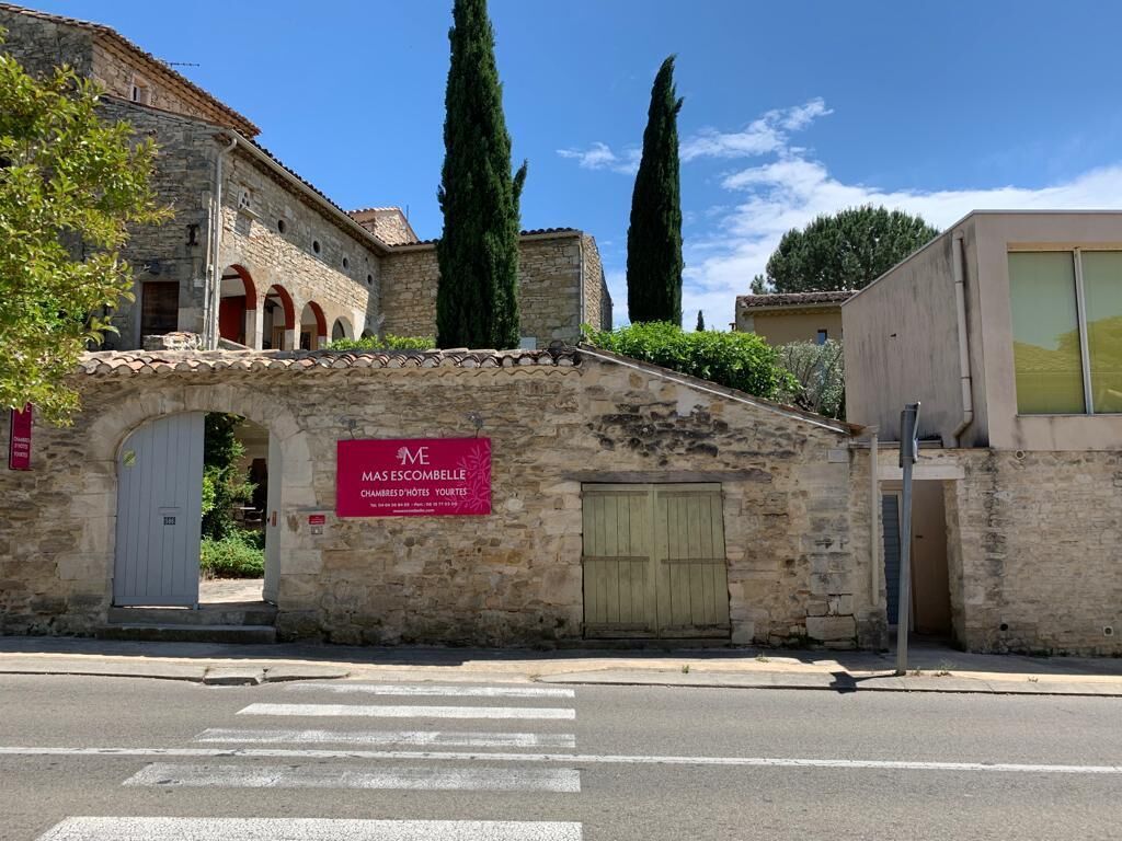 A stone building with a sign reading "MAS ESCAMBLES D'HOUSSES TOUTES."