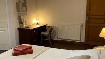 A bedroom with a bed, a desk, a chair, and a lamp.