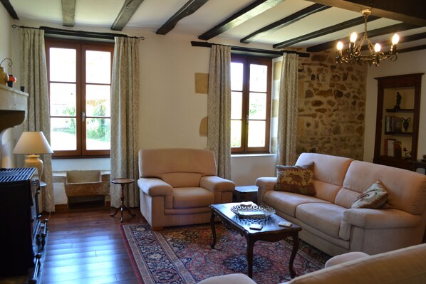 A cozy living room with a fireplace, a sofa, a chair, and a coffee table. - L'Envers (Abzac)