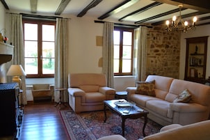 A cozy living room with a fireplace, a sofa, a chair, and a coffee table.