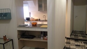 A compact kitchen with a microwave, sink, and orange fruit on the counter. - Bed and Breakfast New Morning (Rome)