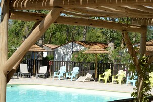 Una piscina al aire libre de temporada, sombrillas