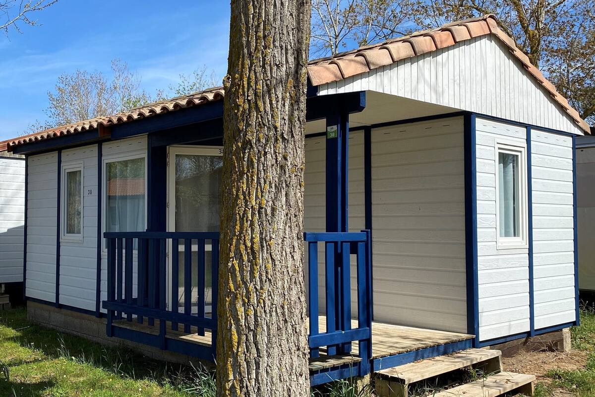 A small, single-story mobile home with a porch and a window.