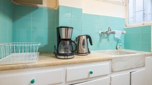 A kitchen with teal tiles, a coffee maker, a kettle, and a sink. - Acropolis View Paradise Apartments (Athens)