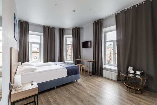 Relax in a serene space with a comfortable bed, flat-screen TV, and convenient amenities.