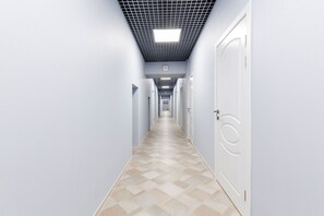 Leading to an entrance, this hallway features a checkered floor and a central light fixture.