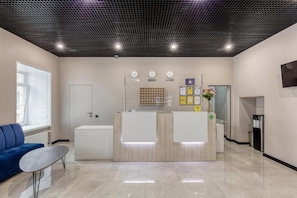 Reception area with a reception desk, sofa, and amenities.