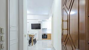 Cozinha moderna com forno embutido e televisão de tela plana fixada acima do balcão.