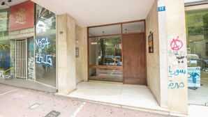 A building entrance with a glass door, a wooden door, and a sign indicating the number 50. - Athens Crown Paradise Apartments (Athens)