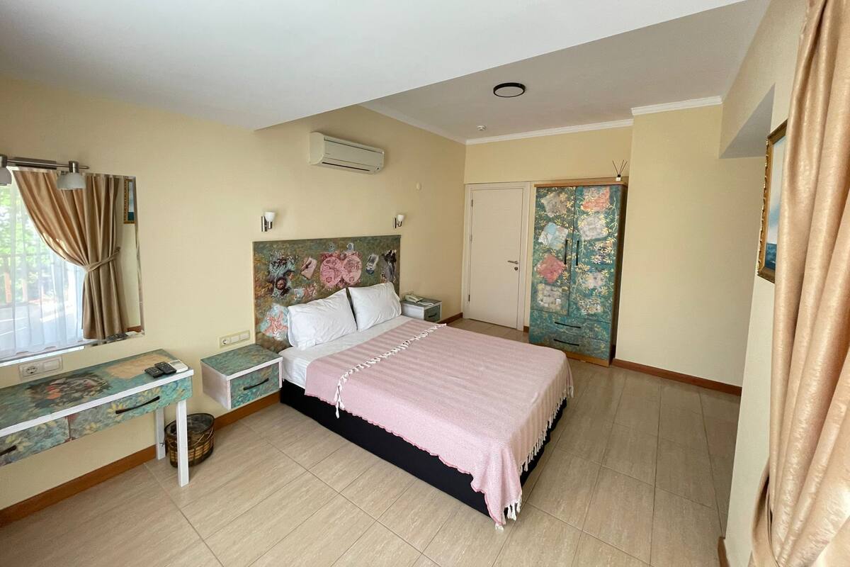 A bedroom with a bed, bedside table, and a wardrobe.