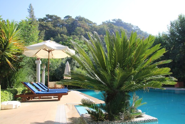 Una piscina al aire libre de temporada, sombrillas