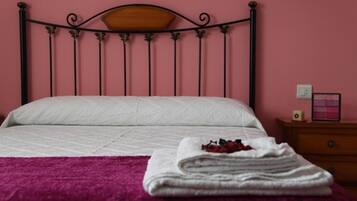 A bed with a wooden headboard, a white bedspread, and a purple blanket.